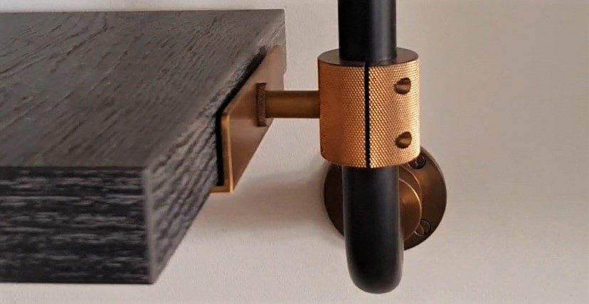 Close-up of a knurled brass collar and machined shelf bracket
