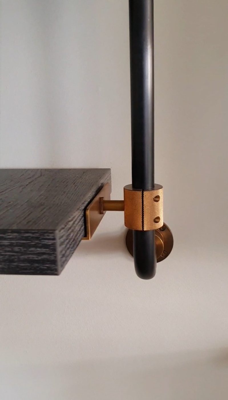 Dark bar shelving with a knurled brass collar and shelf bracket