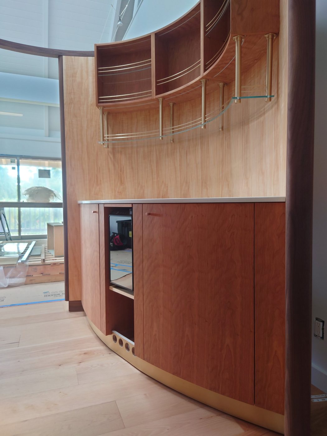 Curved cherry bar with brass uprights, rails and glass shelves