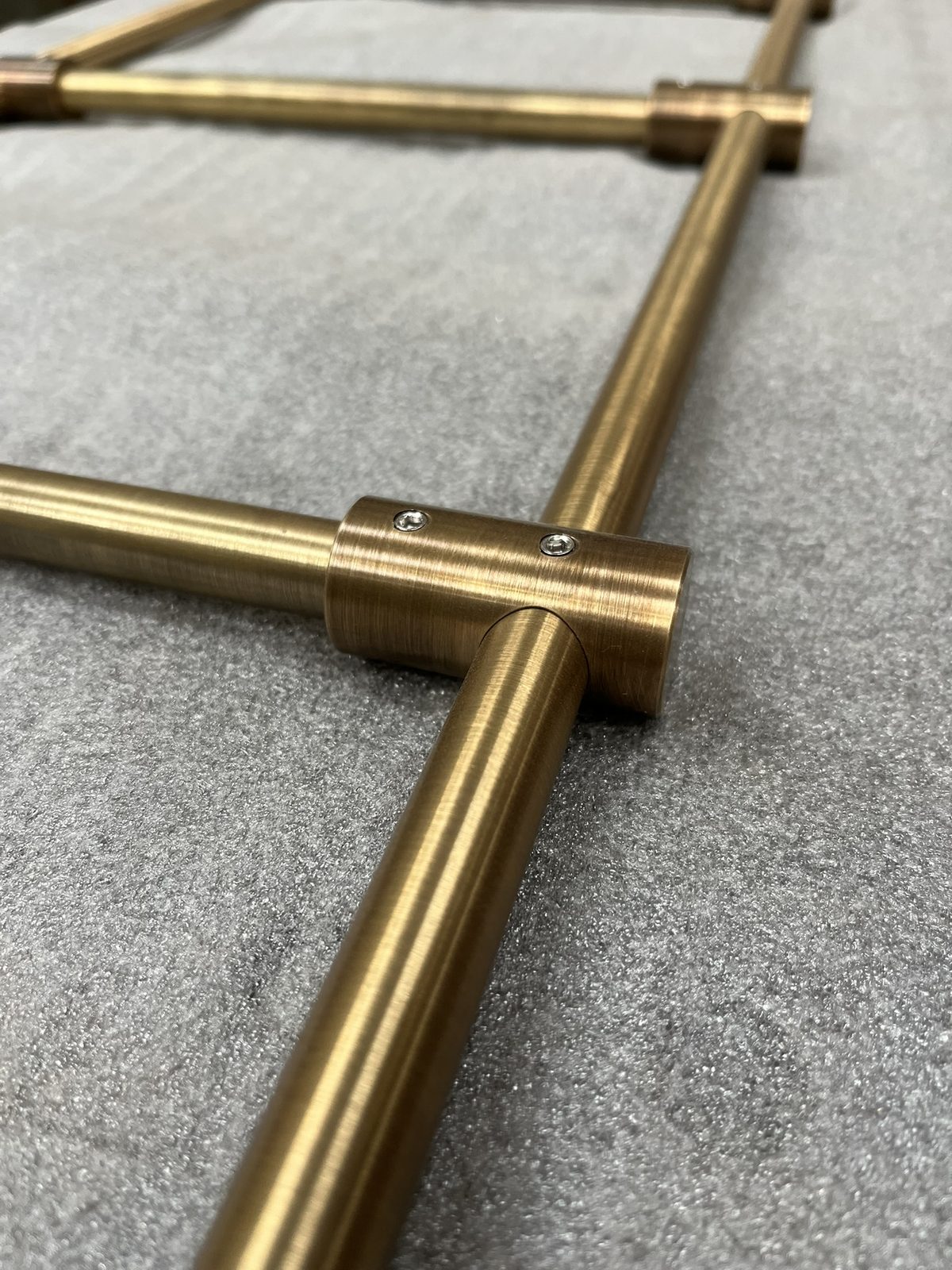 A brass corner connector joining an upright and a shelf rail