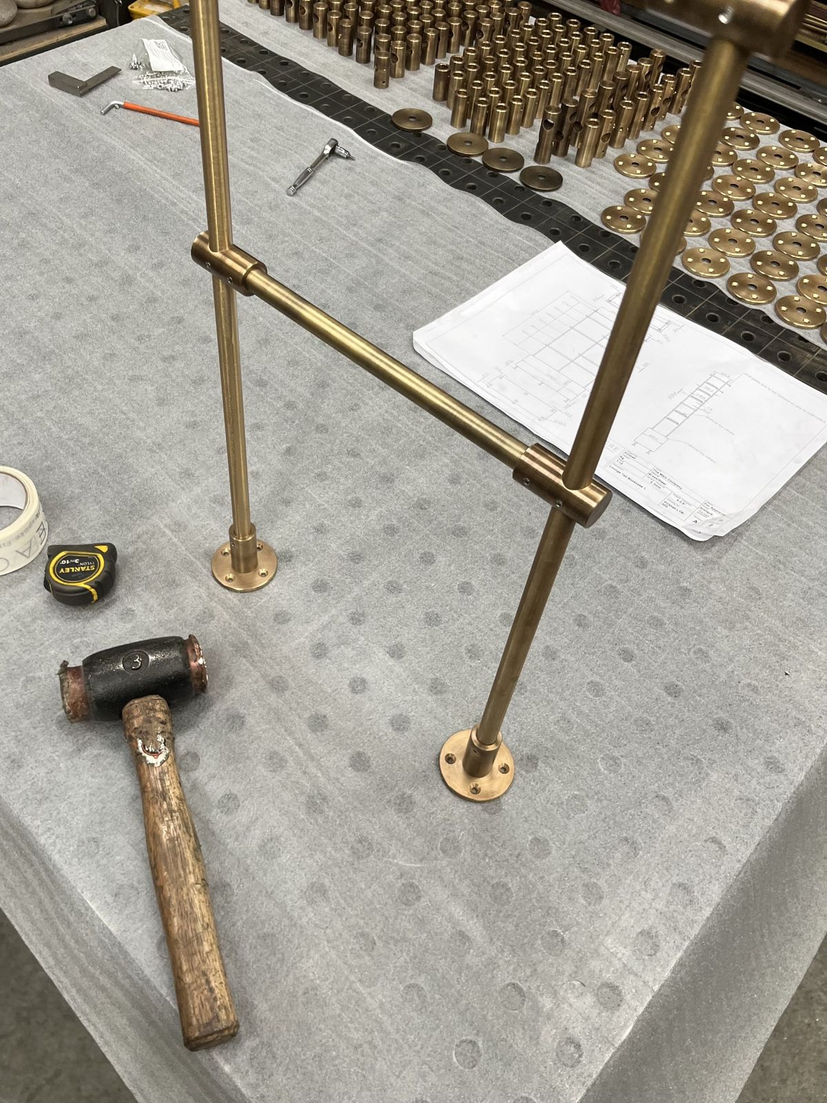 A brass frame being put together on the workshop bench