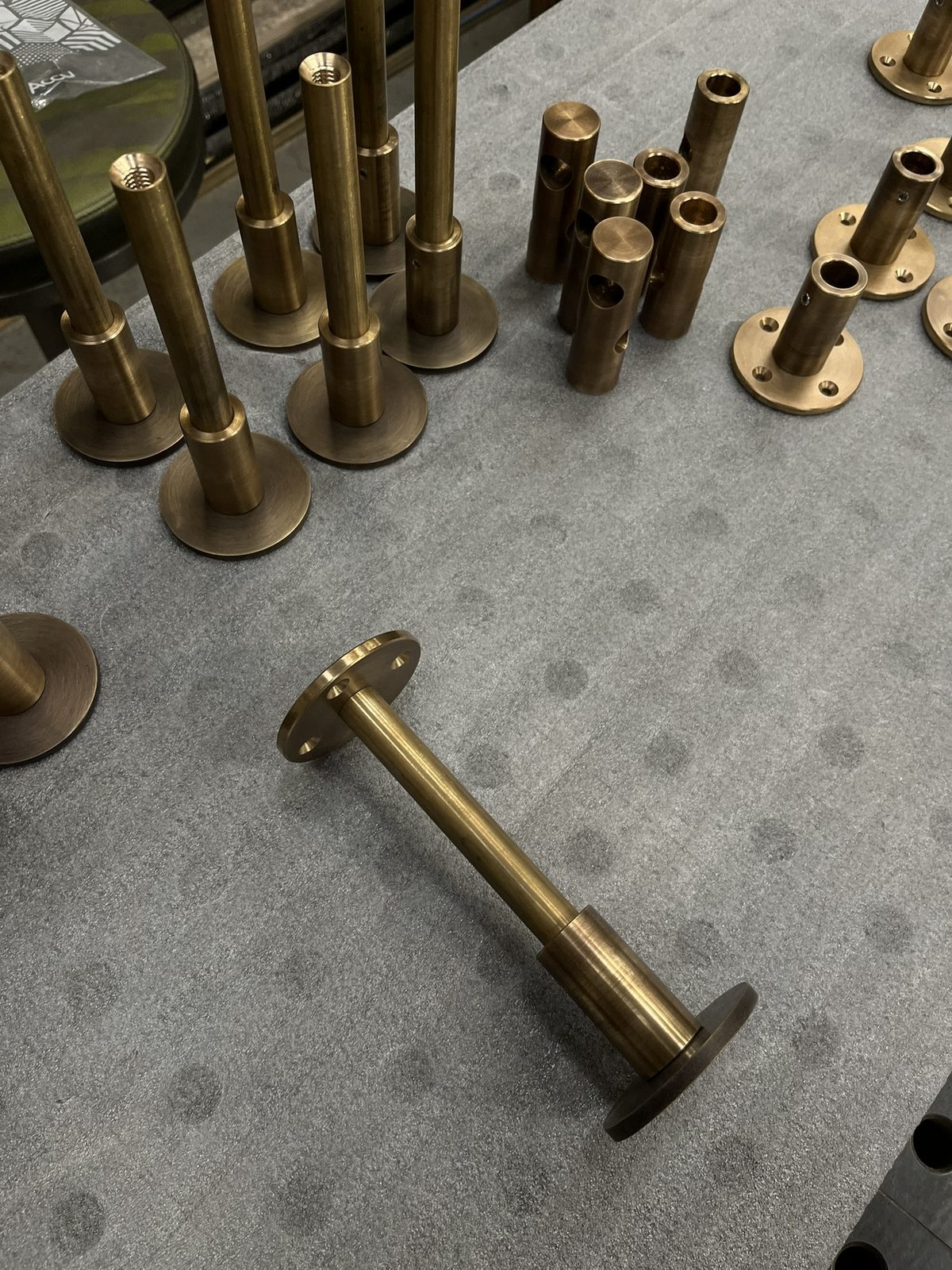 A finished brass upright and base plate lying on the bench