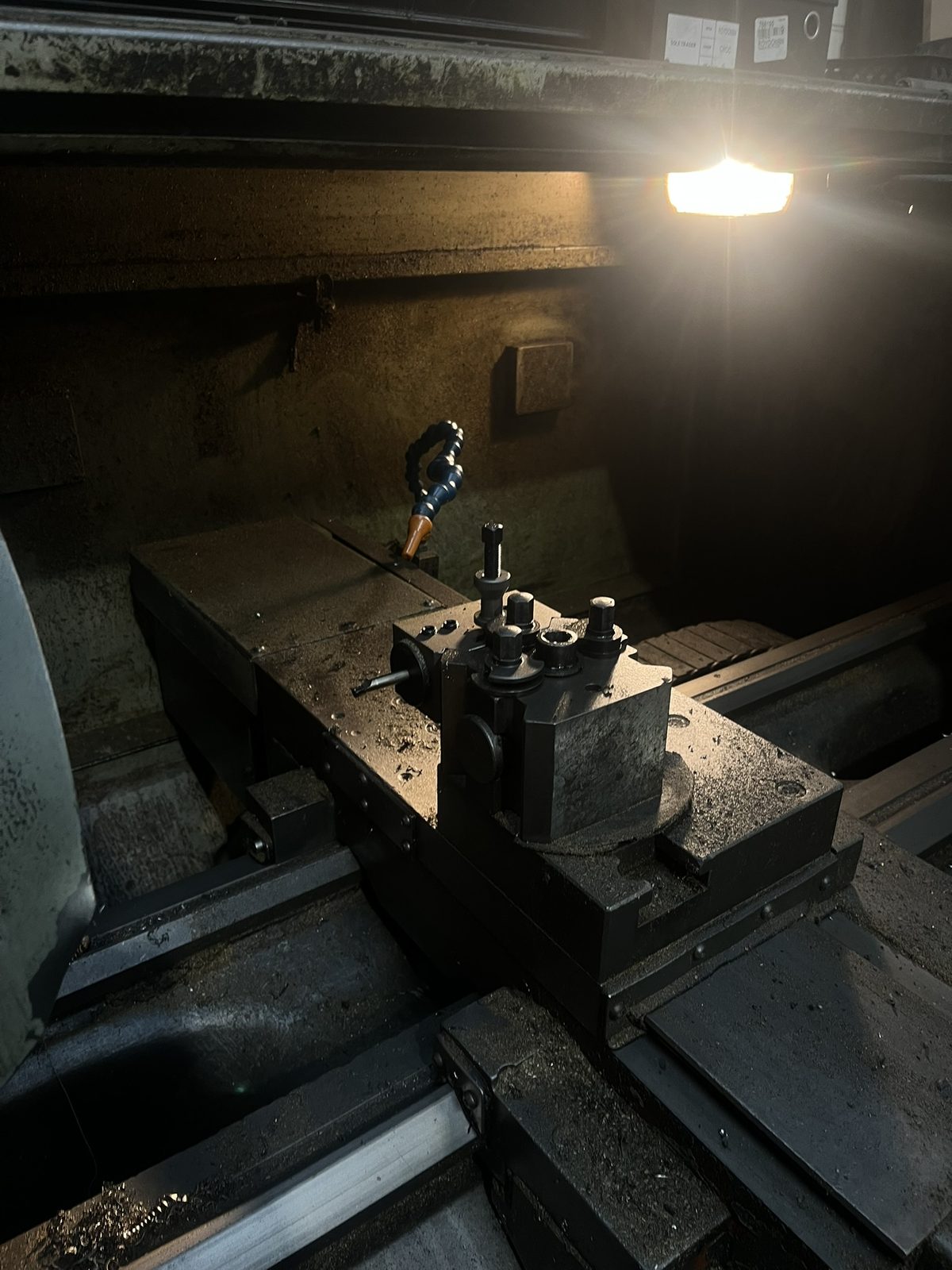 The toolpost of the lathe in the Brass+Co workshop, under a work light